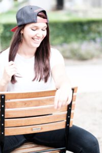 Portrait von Larissa lachend auf einer Holzbank – freies Fotoprojekt Stationshoot, Fotograf Heilbronn-Böblingen