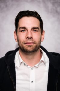 Mitarbeiter der Pflegestation im Portrait, elegant gekleidet vor grauem Hintergrund – Portraitfotografie für Pflegedienste, Fotograf Heilbronn