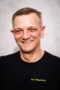 Mitarbeiter der Pflegestation im Portrait, freundlich lächelnd vor hellem Hintergrund – Portraitfotografie für Pflegedienste, Fotograf Heilbronn