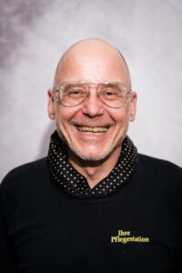 Älterer Mitarbeiter der Pflegestation mit Brille, herzlich lächelnd im Portrait – Portraitfotografie für Pflegedienste, Fotograf Heilbronn