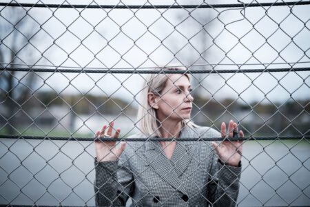 Portraitfotografie Nürnberg: Frau blickt nachdenklich durch einen Maschendrahtzaun – Fotoshooting mit Fotograf Peter aus Heilbronn Portraitfotografie Nürnberg: Frau blickt nachdenklich durch einen Maschendrahtzaun – Fotoshooting mit Fotograf Peter aus Heilbronn