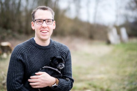 Mann im Pullover mit Hund im Arm im Freien, lockeres Portrait – Fotograf aus Heilbronn