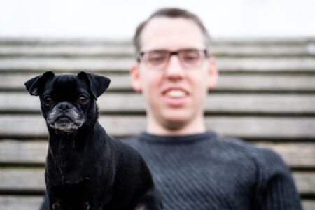 Mann lacht mit Hund vor Holzwand, fröhliches Portrait – Fotograf aus Heilbronn
