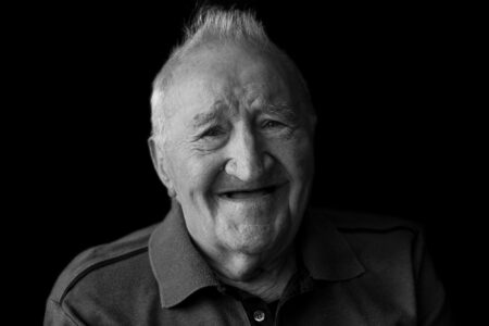 Schwarz-weiß-Portrait eines Seniors mit sanftem Lächeln im Fensterlicht – Projekt Lebensspuren, Fotograf Heilbronn-Allgäu-Hamburg-Bremen