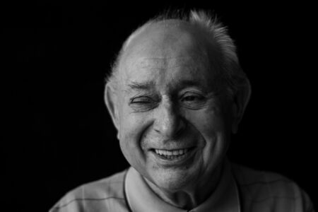 Schwarz-weiß-Portrait eines Seniors mit warmherzigem Lächeln im Fensterlicht – Projekt Lebensspuren, Fotograf Heilbronn-Allgäu-Hamburg-Bremen