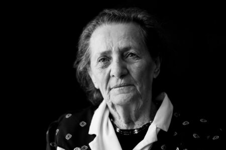 Schwarz-weiß-Portrait einer Seniorin mit ernstem, konzentriertem Ausdruck im Fensterlicht – Projekt Lebensspuren, Fotograf Heilbronn-Allgäu-Hamburg-Bremen