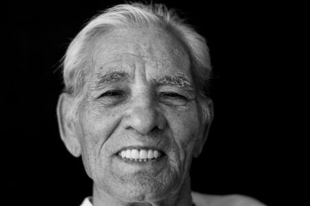 Schwarz-weiß-Portrait eines strahlend lächelnden Seniors im Fensterlicht – Projekt Lebensspuren, Fotograf Heilbronn-Allgäu-Hamburg-Bremen