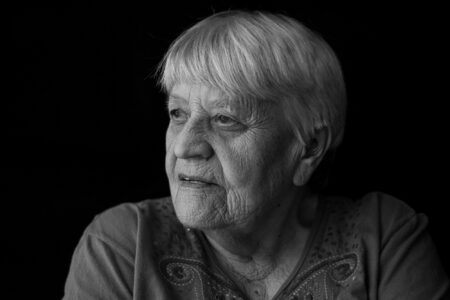 Schwarz-weiß-Portrait einer Seniorin im Profil mit nachdenklichem Blick im Fensterlicht – Projekt Lebensspuren, Fotograf Heilbronn-Allgäu-Hamburg-Bremen