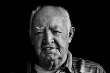 Schwarz-weiß-Portrait eines Seniors im gestreiften Hemd mit nachdenklichem Blick im Fensterlicht – Projekt Lebensspuren, Fotograf Heilbronn-Allgäu-Hamburg-Bremen