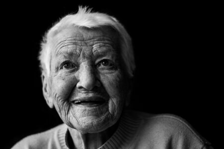 Schwarz-weiß-Portrait einer Seniorin mit tiefen Falten und ausdrucksstarkem Blick im Fensterlicht – Projekt Lebensspuren, Fotograf Heilbronn-Allgäu-Hamburg-Bremen