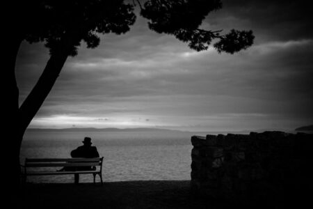 Ein Mann auf einer Bank am Meer, irgendwo in Kroatien. Das Wanderobjektiv mit dem Fotografen aus Heilbronn auf großer Reise nach Griechenland. XT422532_2023_02_Wanderobjektiv-copyright-creazyfoto-Reise-Fotograf-Heilbronn