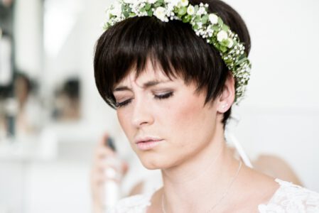 Braut mit Blumenkranz im kurzen Haar beim letzten Styling, Getting Ready in Reisach