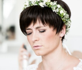 Braut mit Blumenkranz im kurzen Haar beim letzten Styling, Getting Ready in Reisach