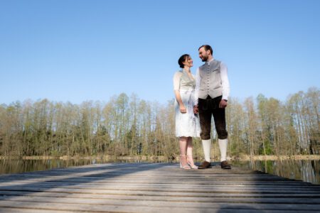 Das Brautpaar am Ende des Stegs, das Wasser spiegelglatt – Hochzeit im Allgäu