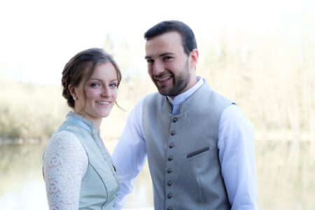 Portrait des Brautpaars in Tracht vor dem Wasser – Hochzeitsfotograf Allgäu