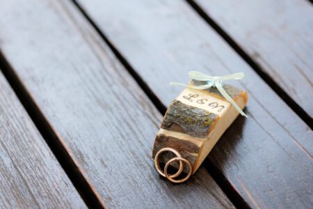 Eheringe auf Holz, daneben ein Anhänger mit dem Hochzeitsdatum – Hochzeit in Waal, Allgäu
